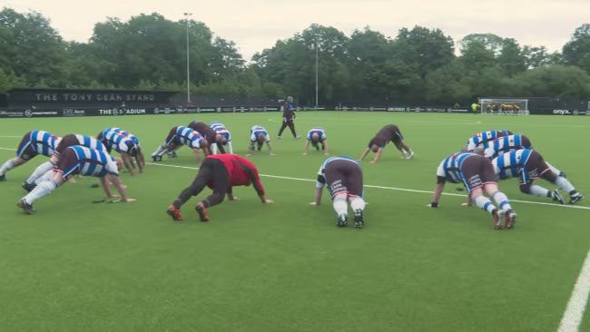 TV still of the Reading XL team doing push-ups on a training pitch