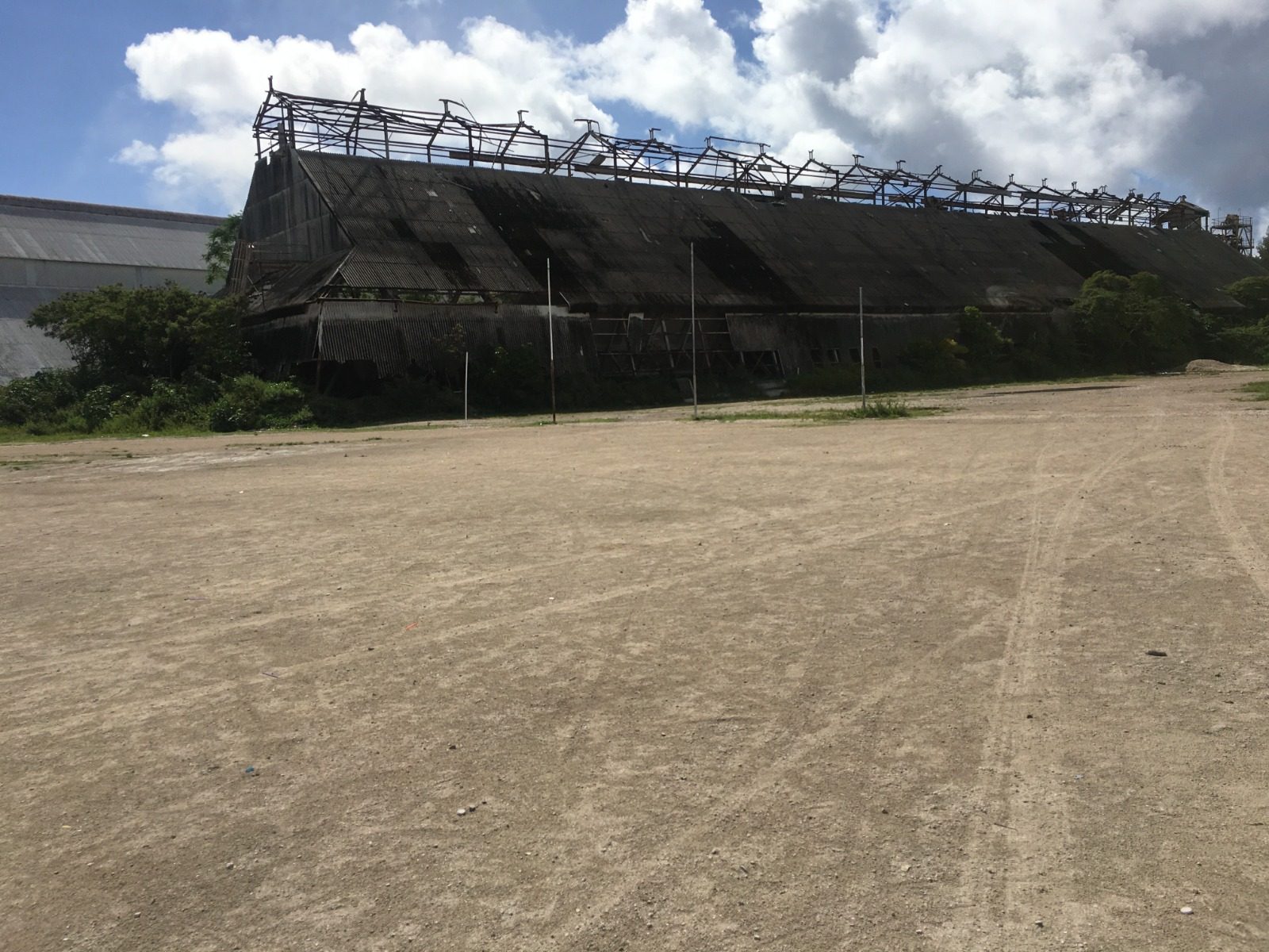 An empty sports ground on Naoero with a covered stand and the ocean beyond